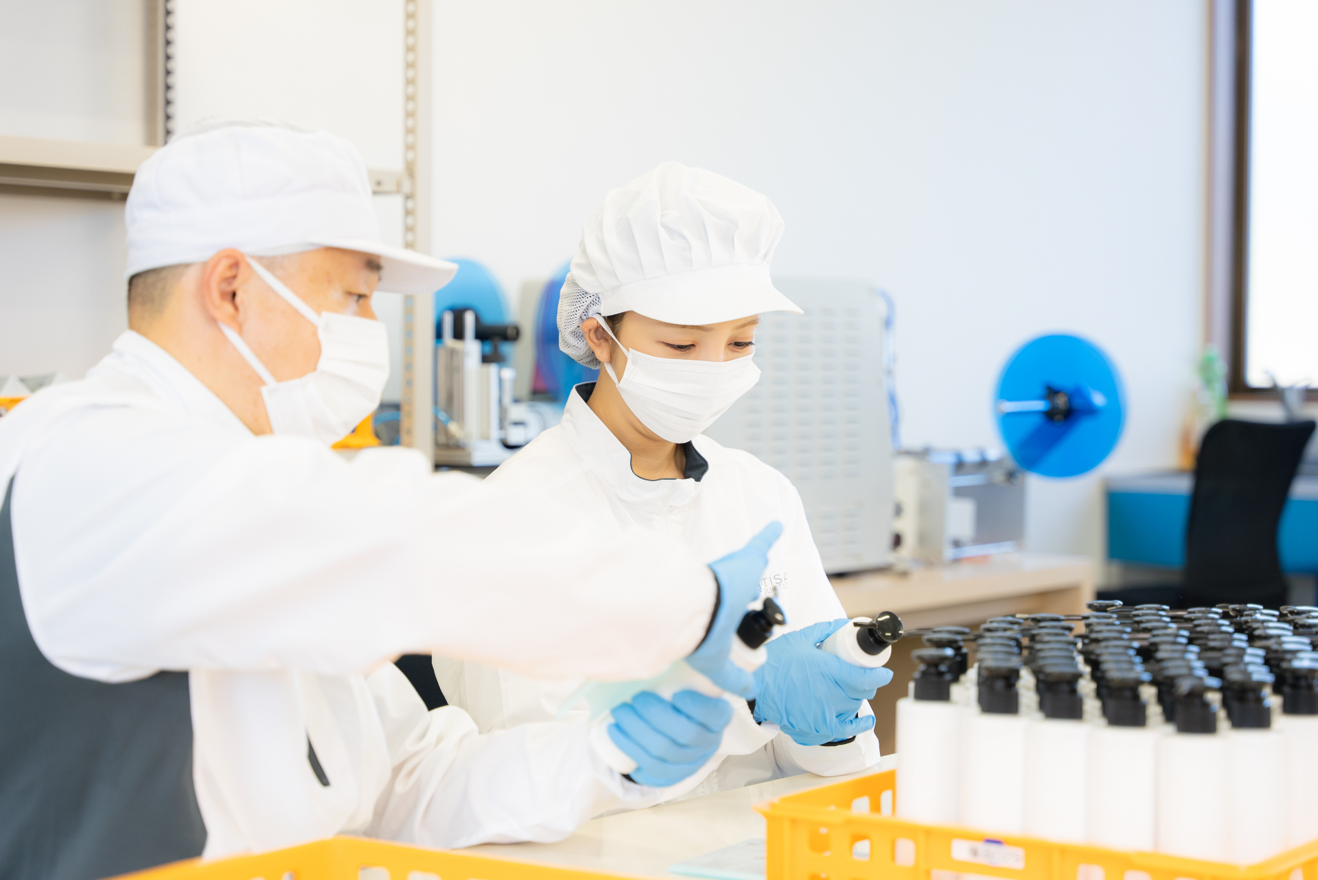 Filling and capping inspection on the cosmetics production line, checked by hand at every step.