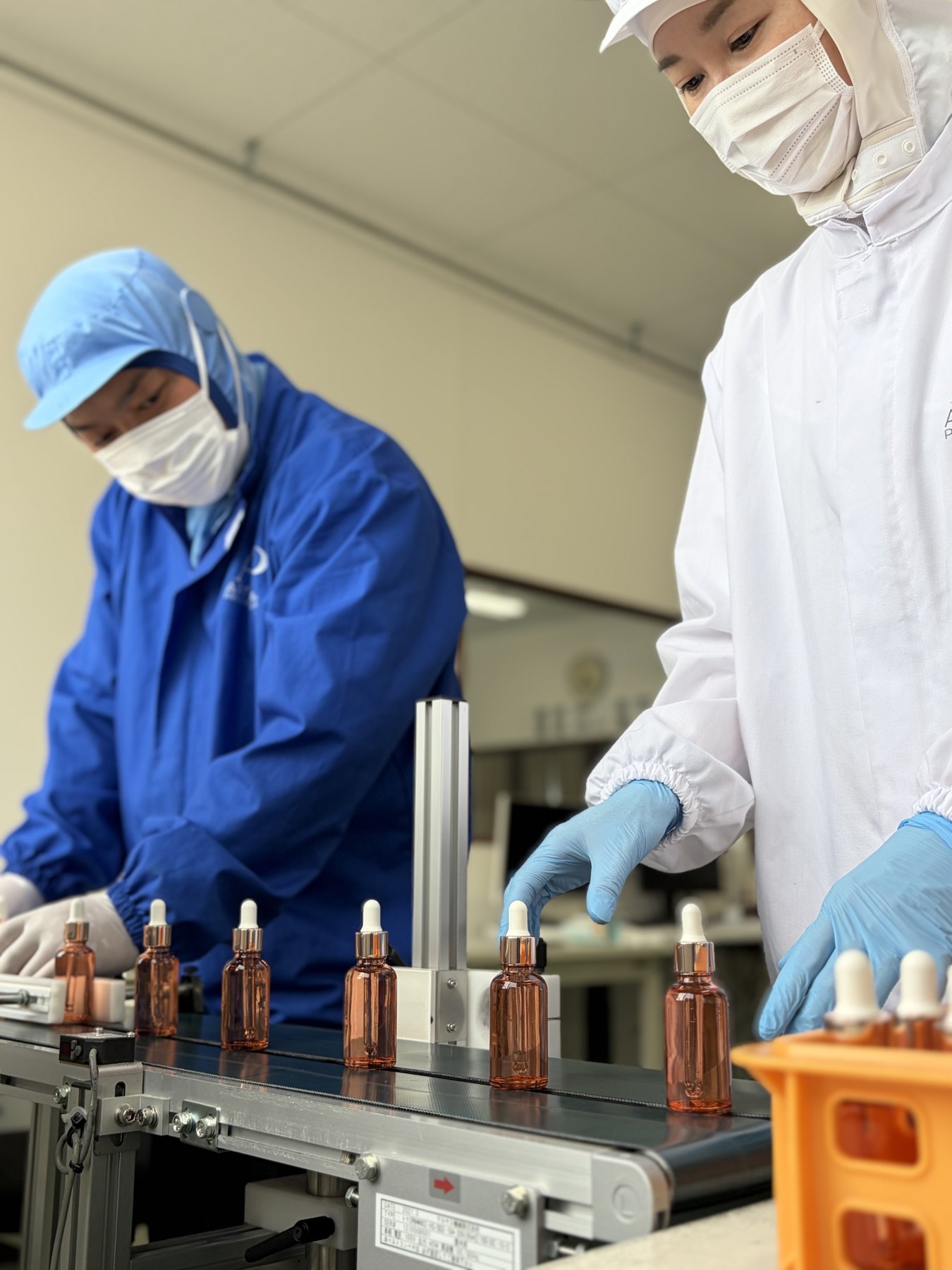 Serum bottles moving along the filling line under a double check.