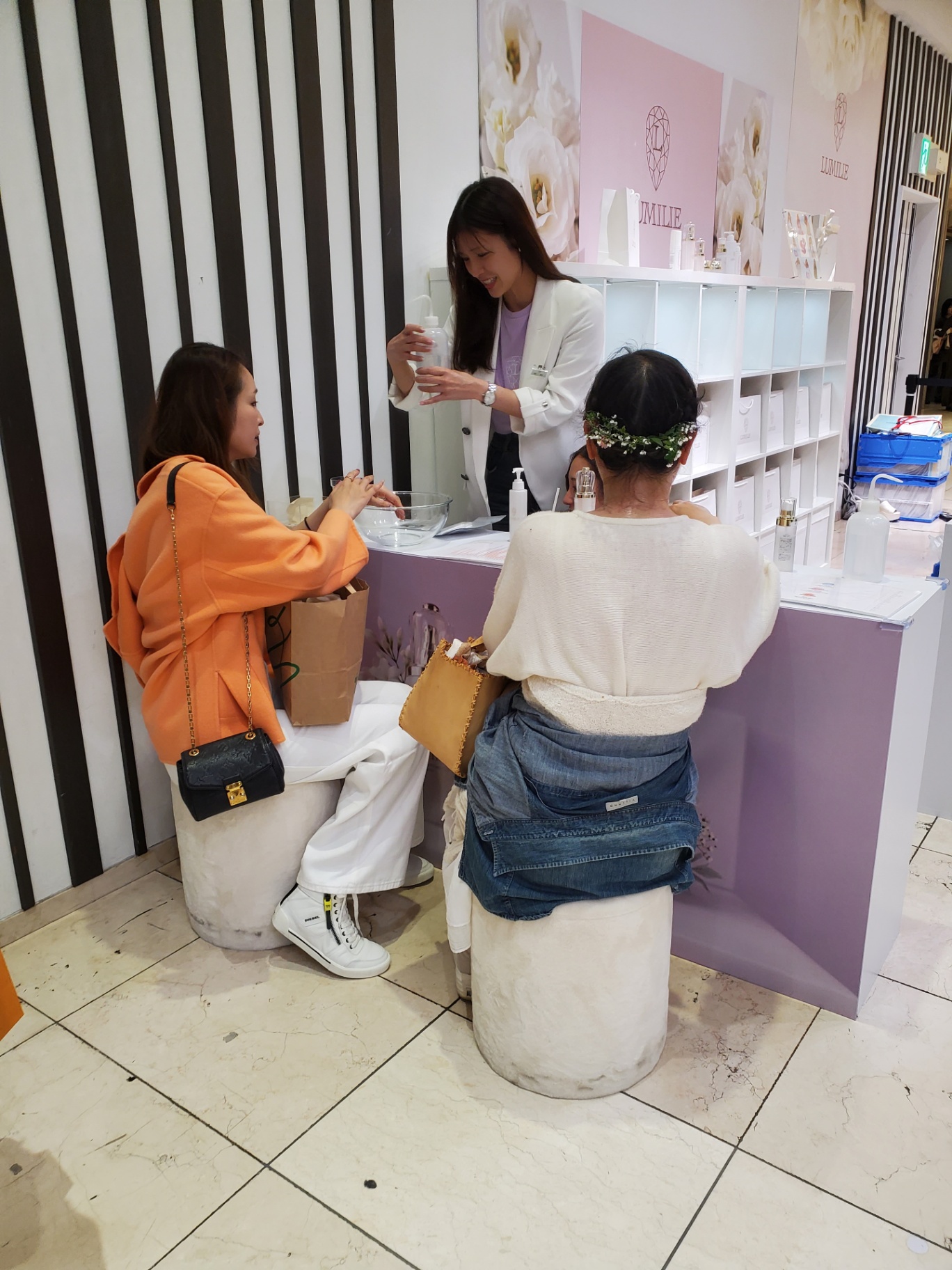 Customers trying products at the LUMILIE pop-up counter.